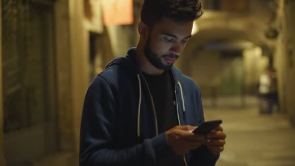 Όμορφος νεαρός άνδρας χρησιμοποιεί smartphone τη νύχτα — Αρχείο Βίντεο