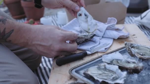 Mann serviert frische Austern zum Picknick — Stockvideo