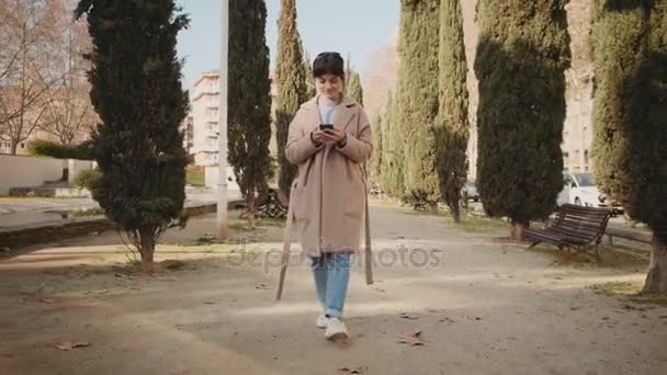 Jolie femme utilise smartphone dans le parc — Video