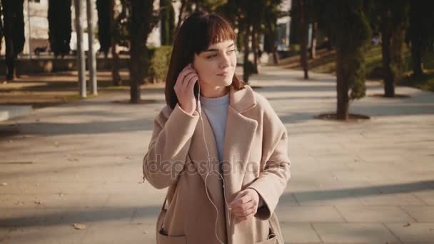 Mujer bonita utiliza teléfono inteligente en el parque — Vídeo de stock