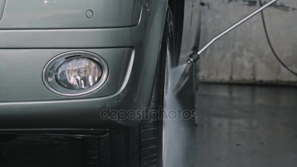 Мужчина чистит большой фургон или машину на автомойке — стоковое видео