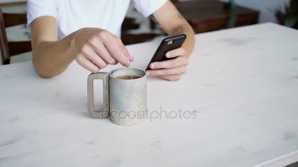 Unrecognizable man steeps herbal tea in big mug — Stock Video