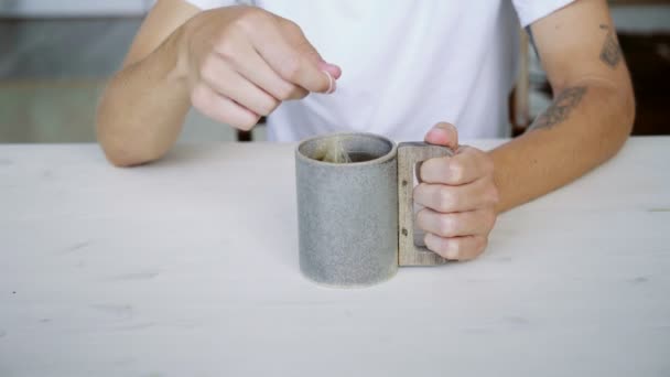 Homem irreconhecível mergulha chá de ervas em grande caneca — Vídeo de Stock