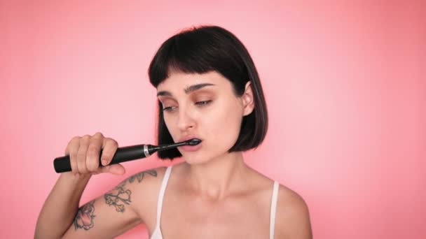 Toothbrush and attractive brunette on color backgrounds — Stock Video