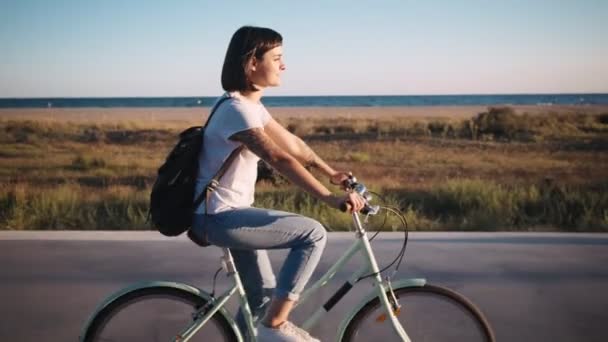 Brunett cykling i strandpromenaden — Stockvideo