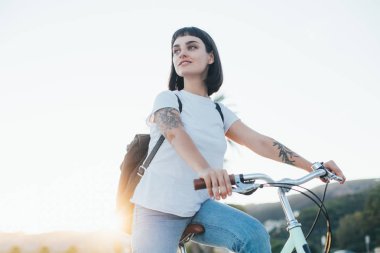 Günbatımı üzerinde bisikletle güzel kadın