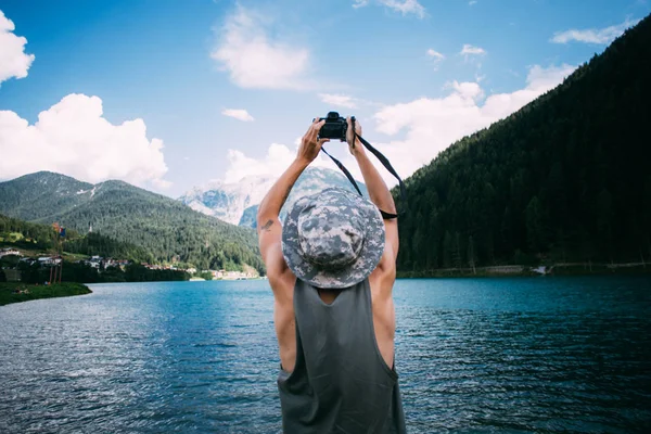 Man in hat makes photos of mountains — Stock Photo, Image