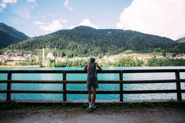 Mannen står nästa till staketet och tittar på berget — Stockfoto