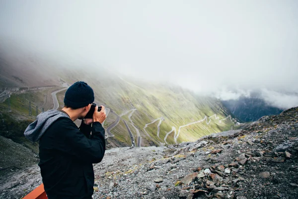 Uomo in cima alla montagna fa foto — Foto Stock