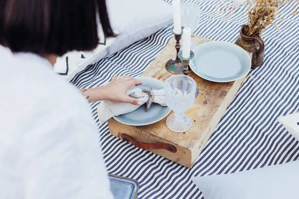 Beautiful woman decorates dinner table — Stock Photo, Image