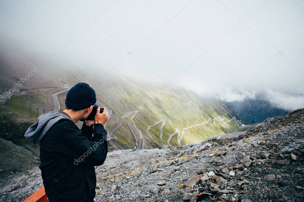 man on top of mountain makes photo