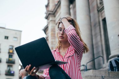 Dizüstü bilgisayar ile merdivenlerde çekici kadın oturur