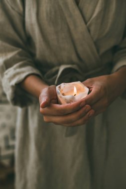 Kadın keten elbise içinde mum tutan