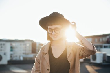 Gün batımında fedora şapkalı güzel kadın