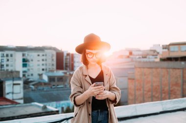 Smartphone kullanarak kadın günbatımı fotoğrafı