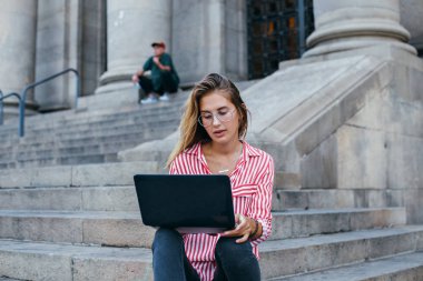 Kadın ofis binası merdivenlerinde oturur 