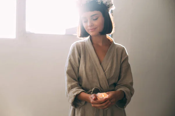 Wanita dalam jubah linen memegang lilin — Stok Foto