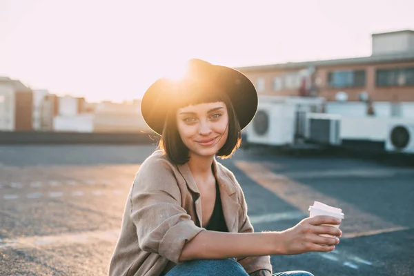 Beautiful woman holds coffee cup on sunset — Stock Photo, Image