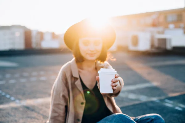 Attractive woman holds coffee cup on sunset — Stock Photo, Image