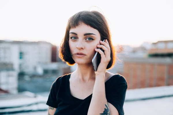 Mujer bonita habla en el teléfono inteligente en la puesta del sol — Foto de Stock