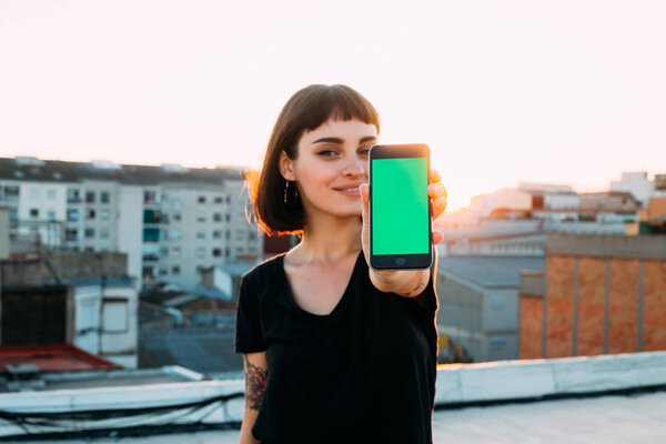 Красивая женщина держит смартфон перед камерой
