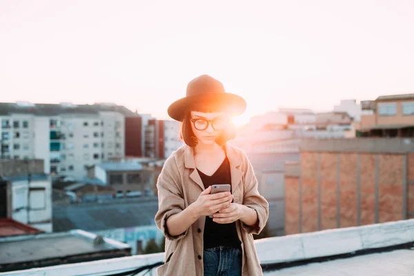 Sunset kuva nainen käyttää älypuhelinta — kuvapankkivalokuva