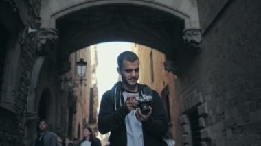 Eski şehirde kamera ile genç adam yürüyor
