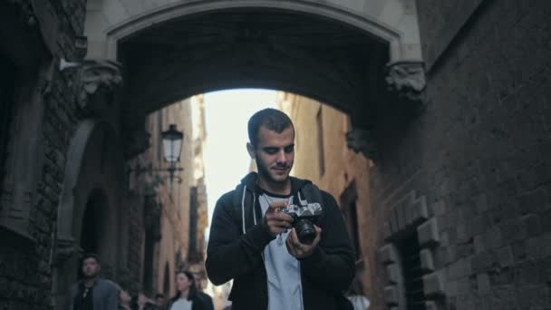 Ung man går med kameran i gamla stan — Stockvideo