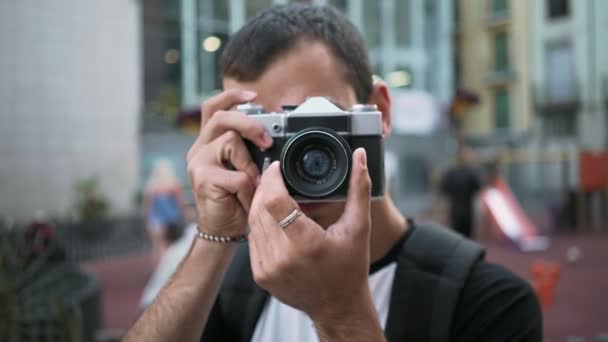 Jonge man loopt met camera in de oude stad — Stockvideo