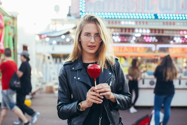 Blonde woman with red glazed candy — Fotografie, imagine de stoc