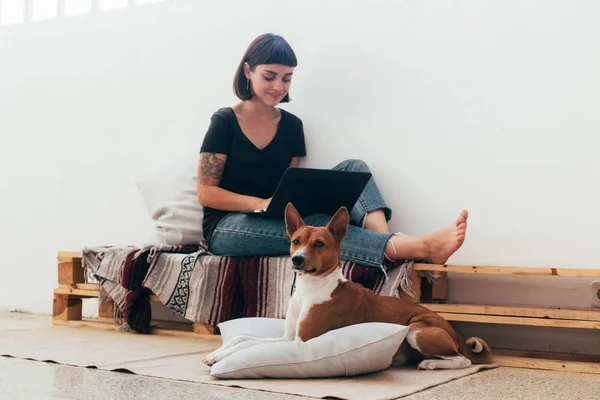 Γυναίκα που εργάζεται στο σπίτι με το σκυλί κατοικίδιων ζώων — Φωτογραφία Αρχείου