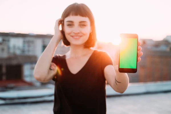 Γυναίκα δείχνει smartphone πράσινη οθόνη — Φωτογραφία Αρχείου