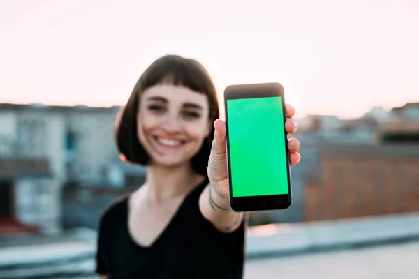 Жінка показує зелений екран смартфона — стокове фото