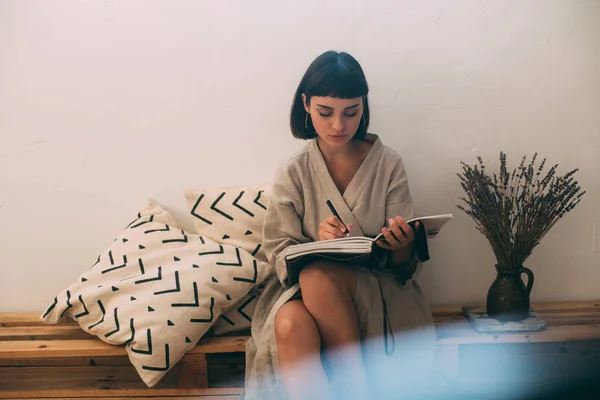 Attractive woman writes notes in diary — Stock Photo, Image