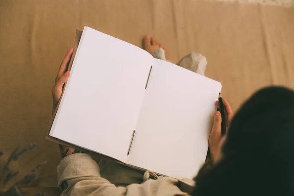 Mulher segurando abriu caderno vazio — Fotografia de Stock