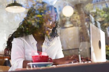 Mutlu ve gülümseyen güzel Afrikalı-Amerikalı kadın kahve dükkanı
