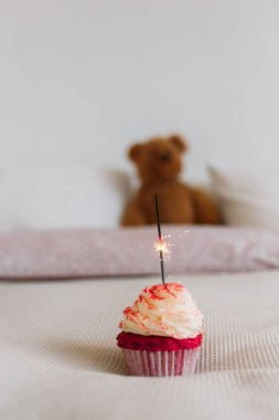 doğum günü kek yatak yanan maytap mum ile arka plan üzerinde oyuncak ayı oyuncak