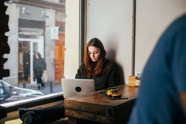 Mujer Usando Portátil Portátil Mientras Está Sentado Pequeño Café Con —  Fotos de Stock