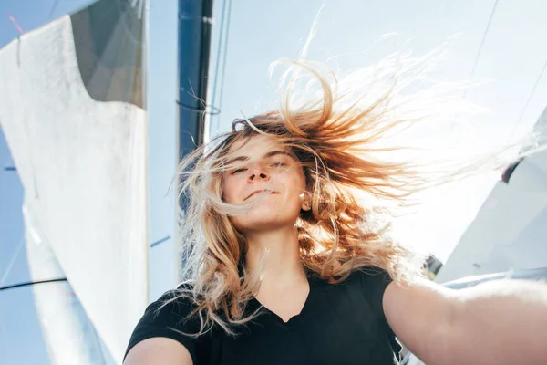 若い美しいブロンドの女性は ヨットの上で Selfie 風が吹くと髪 — ストック写真