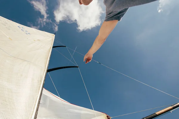 sailor man on yacht boat, sailing in blue ocean water and blue sky above