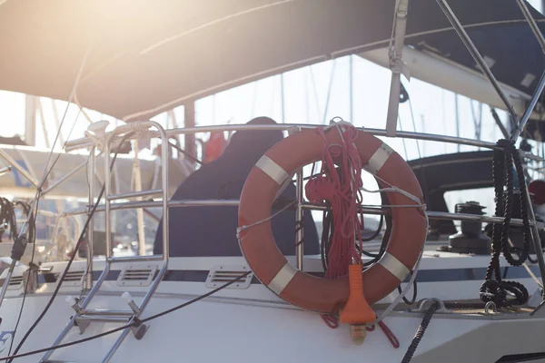 back view of marine Sailor in boat, life saving ring hanging on yacht