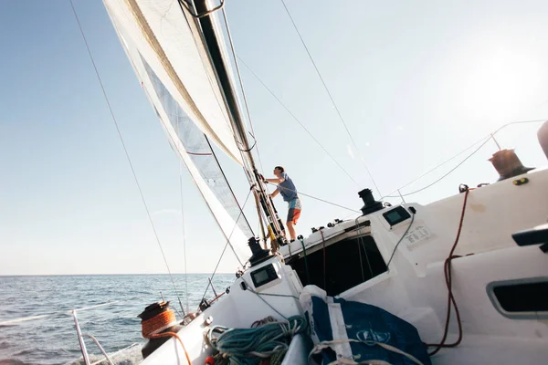 sailor man on yacht boat, sailing in blue ocean water