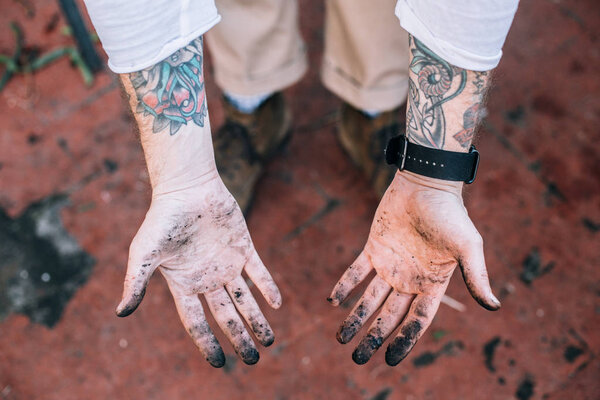 Человек, показывающий грязные руки
