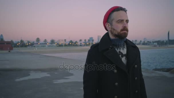 Lonely hipster, sailor man walking toward the sea at sunrise — Stock Video