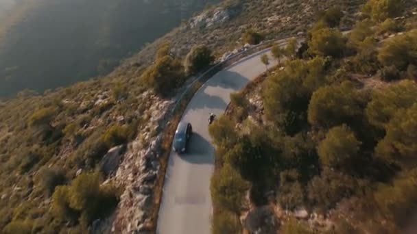 Drohnenaufnahmen über einsamen Reisenden, der mit seinem Motorrad auf epischen Bergstraßen unterwegs ist — Stockvideo