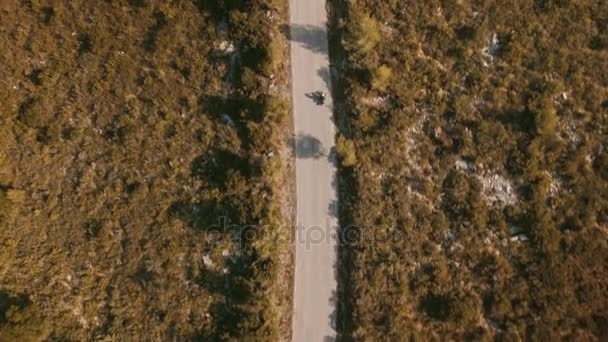 Drone felvételeket, mint magányos utazó, lovaglás a motorkerékpár epikus táj hegyi utakon — Stock videók