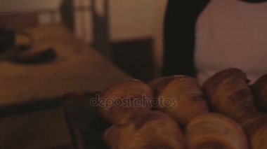 Garson tepsiyi taze kruvasanlar ile taşır