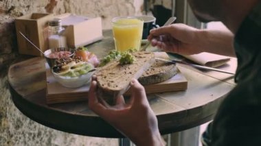 Kadın domates ekmek tost yayılır.