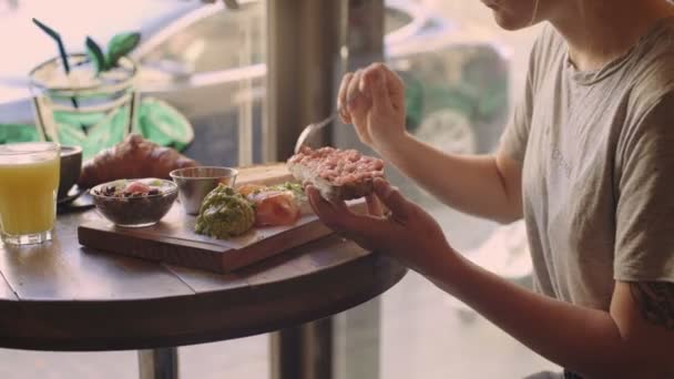Cliente en la cafetería disfruta de tostadas con aguacate — Vídeos de Stock