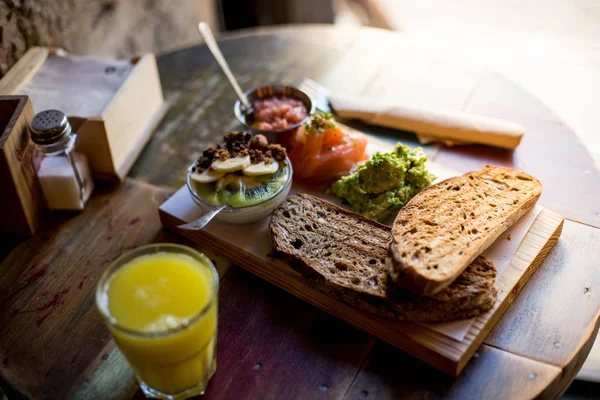 広がるアボカド トマトと新鮮なサーモンと木の板でチーズとカリカリ トースト — ストック写真